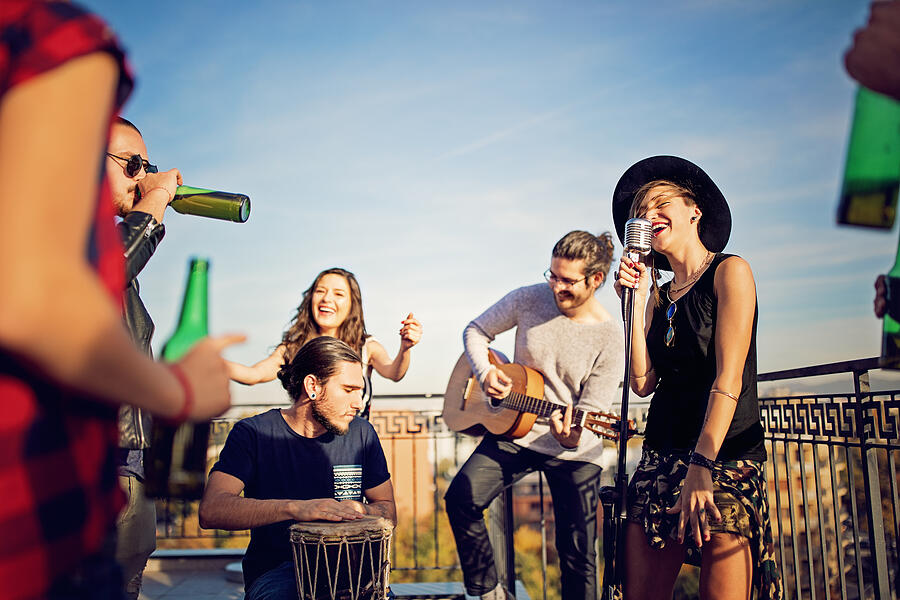 Group of friends are celebrating with a concert on the roof terrace #9 Photograph by Praetorianphoto