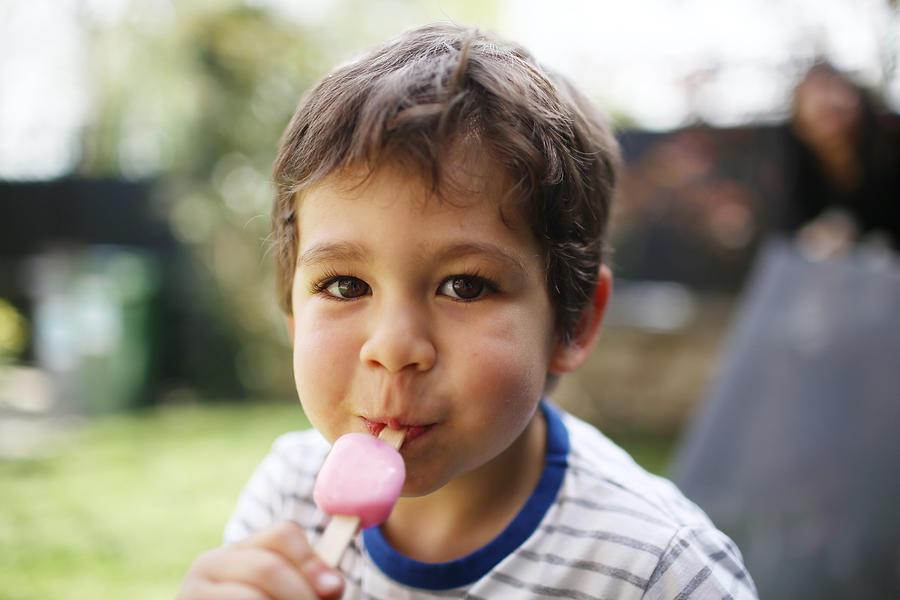 A 3 years old boy eating a ice cream Photograph by Catherine Delahaye