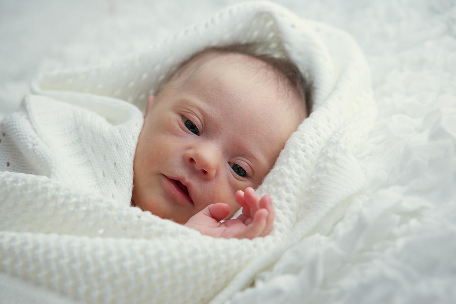 A baby cuddled up in a white blanket Photograph by Eleonora_os
