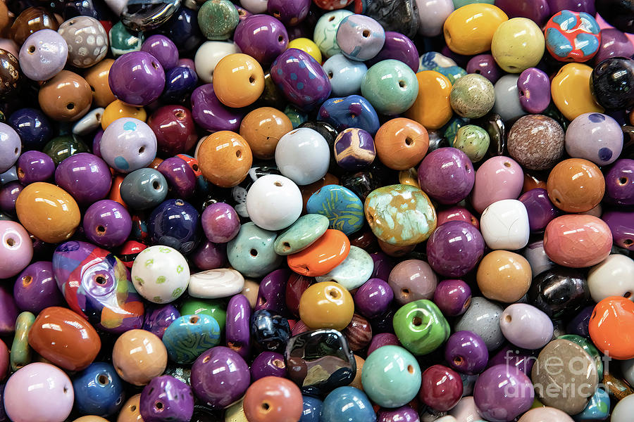 A background of colourful ceramic glazed beads. Traditional African beads for ethnic jewelery and souvenirs. Overhead view Photograph by Jane Rix