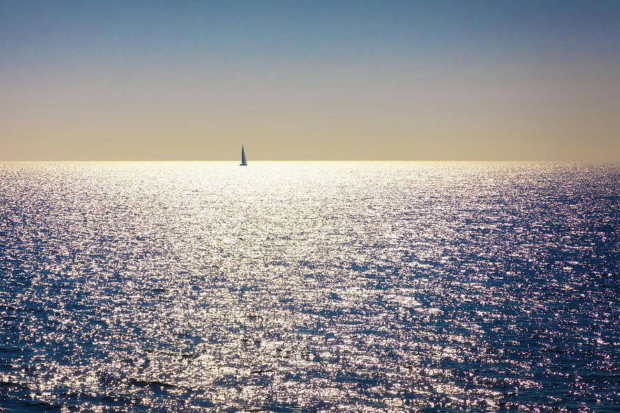 A backlit sailboat at sea Photograph by Jordi Carrio Jamila