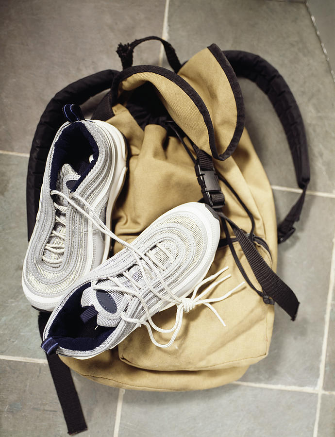 A backpack and gym shoes on a tile floor Photograph by Steve Wisbauer