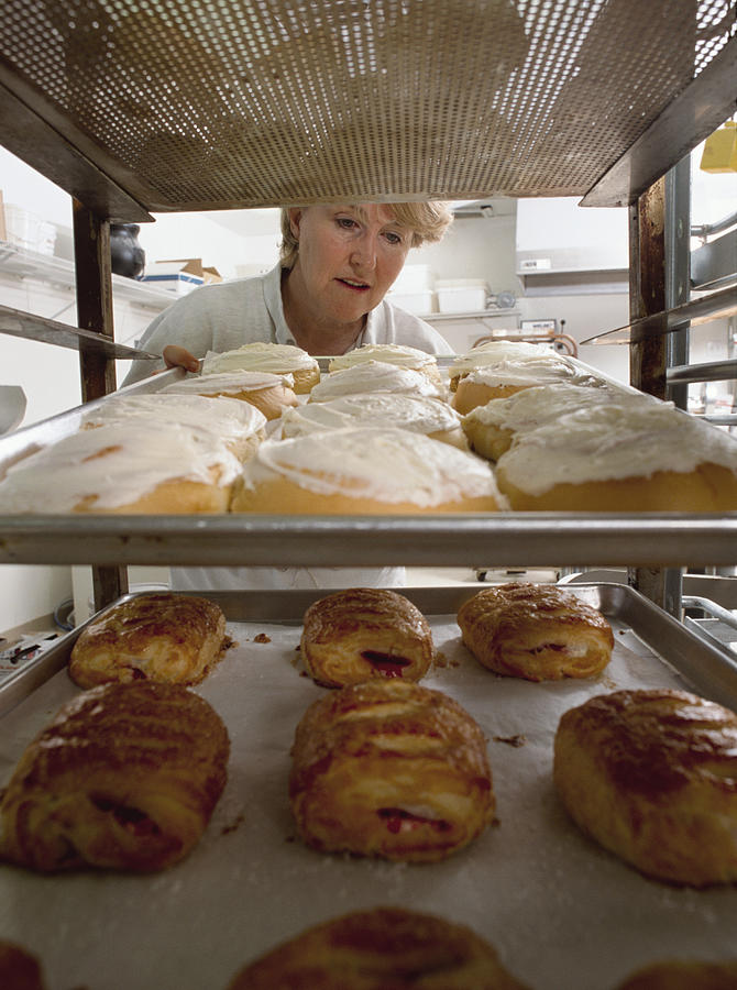 A Baker Inspects A Fresh Batch Of Pastery And Breads Photograph by Photodisc