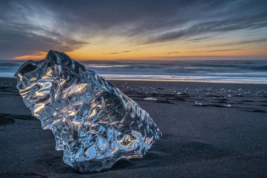 A big block of ice on the beach at sunrise, near the Jokulsarlon lagoon in South Iceland, also calle Photograph by Anges Van der Logt