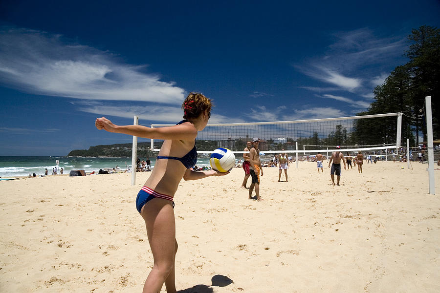 A bikini clad woman prepares to serve in beach volleyball Photograph by Hanis