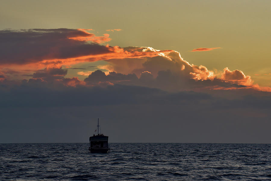 A boat on the sea with sunset light on clouds Photograph by Chun Ju Wu ...