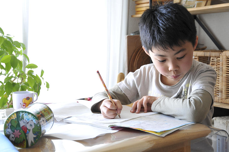 A boy doing homework Photograph by Akiko Aoki
