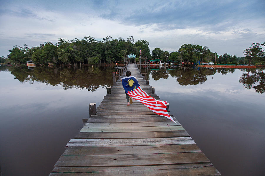 A Boy Running With A Long Malaysian Flag on a Pier / Jetty Photograph by Faidzzainal