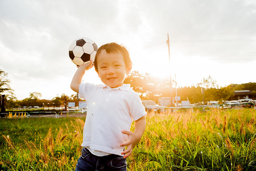 A boy with a soccer ball in hand Photograph by Taiyou Nomachi