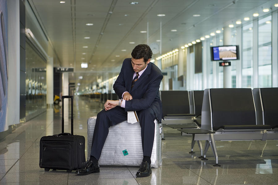 A businessman waiting in the departure lounge. Photograph by Denkou Images