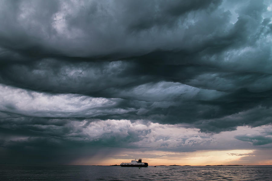 A cargo ship underneath stormy clouds Photograph by Arvid Norberg - Pixels