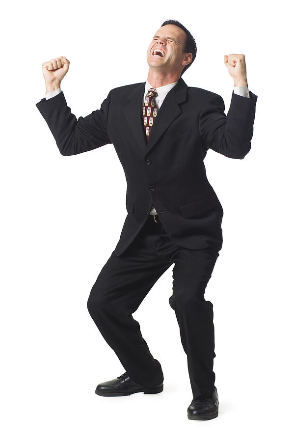A Caucasian Business Man In A Dark Suit Holds Up His Arms In Celebration Photograph by Photodisc