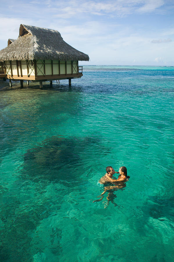 A Caucasian Couple Embrace And Swim Through The Clear Water At A Tropical Resort Photograph by Photodisc