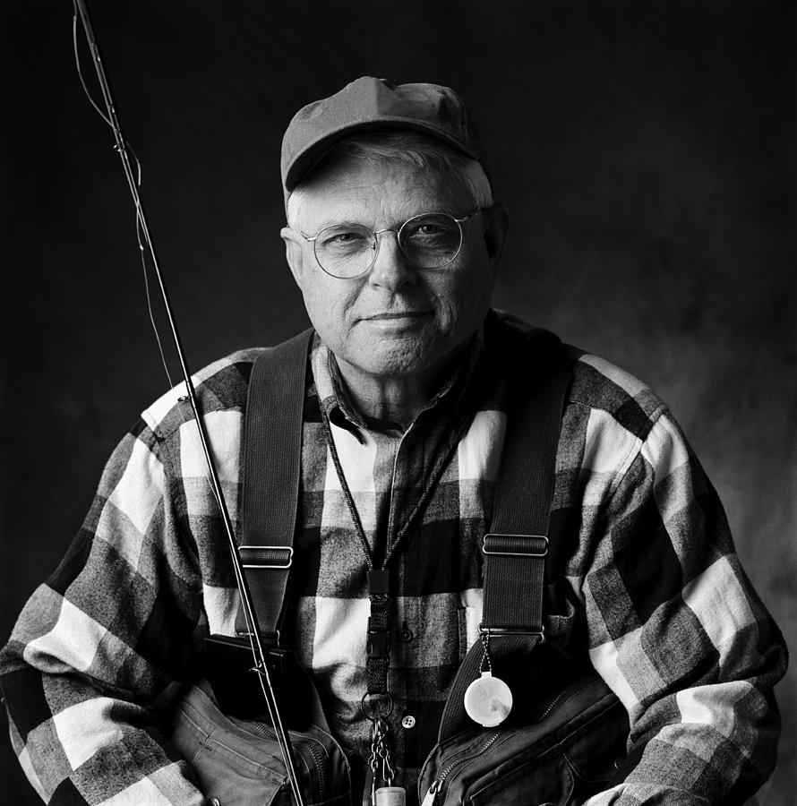 A caucasian elderly man sits in his fly fishing gear Photograph by Photodisc