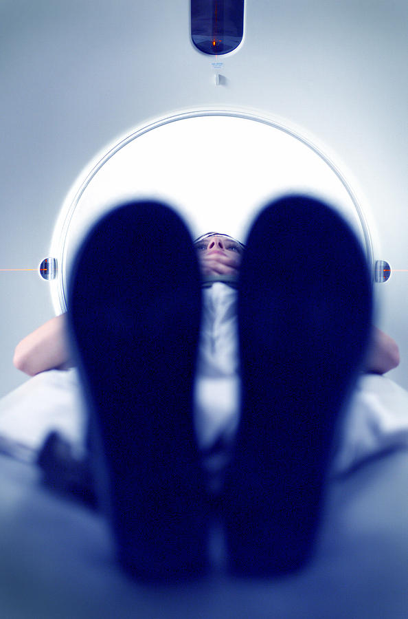 A Caucasian Female Patient Lies Flat As She Goes Through A Cat Scan Machine Photograph by Photodisc
