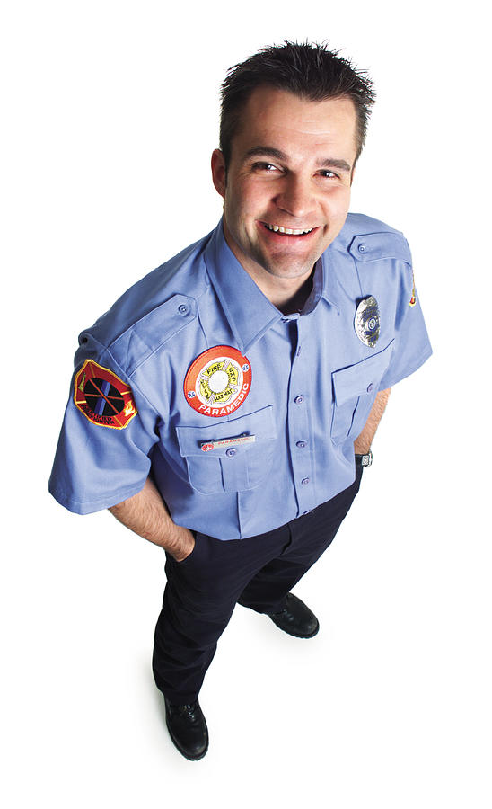 A Caucasian Male Paramedic Dressed In Uniform Stands Smiling As He Looks Up At The Camera Photograph by Photodisc