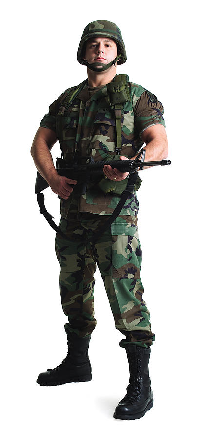 A Caucasian Male Soldier Dressed In Army Fatigues Stands With His Gun Photograph by Photodisc