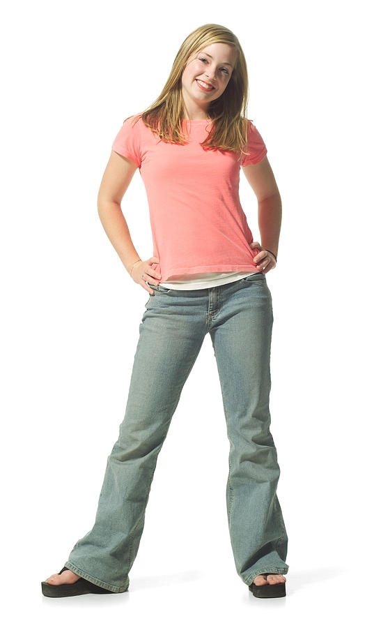 A Caucasian Teenage Blonde Girl In Jeans And A Pink Shirt Smiles Playfully Photograph by Photodisc