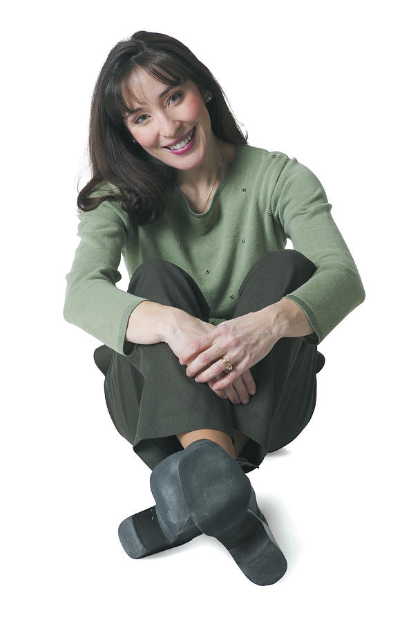A Caucasian Woman Dressed In Green Pants And Blouse Sits Down And Smiles Photograph by Photodisc