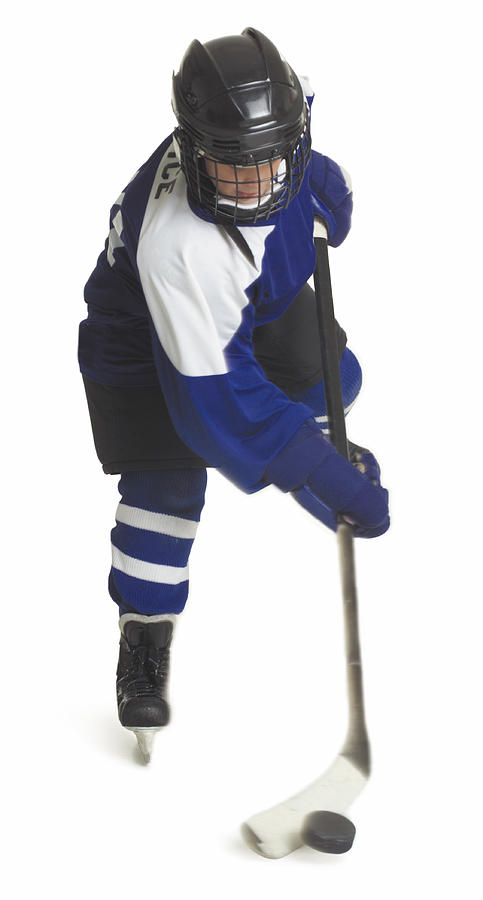 A Child Caucasian Male Hockey Player Dressed  In A Blue White And Black Jersey Skates With His Stick And Puck Photograph by Photodisc