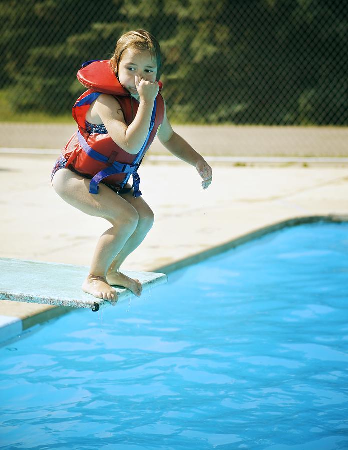 A child jumps off diving board Photograph by Design Pics/Kelly Redinger