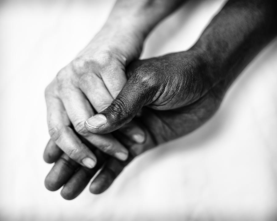 A colored man and a white female holding hands Photograph by Runar Vestli