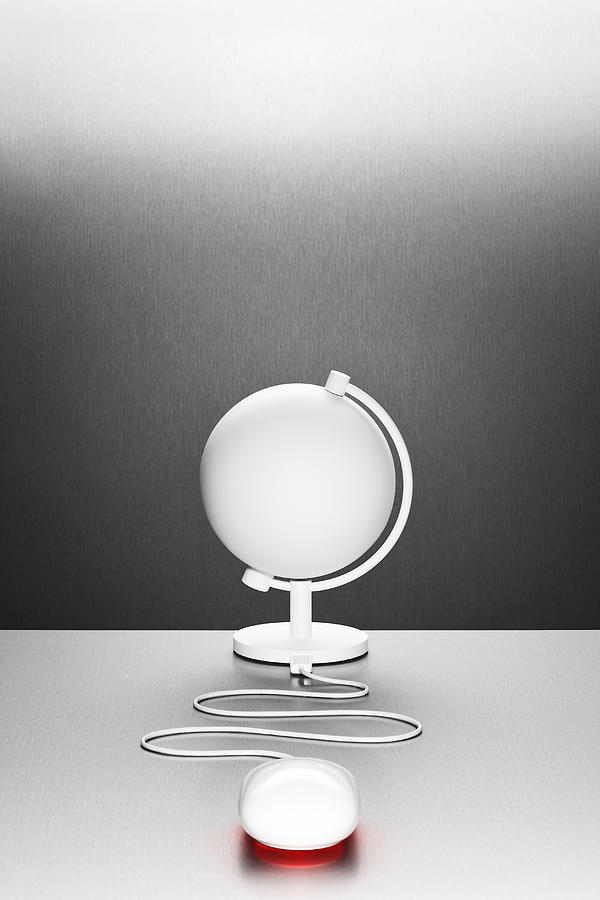 A computer mouse connected to a white desk globe Photograph by Creative Crop