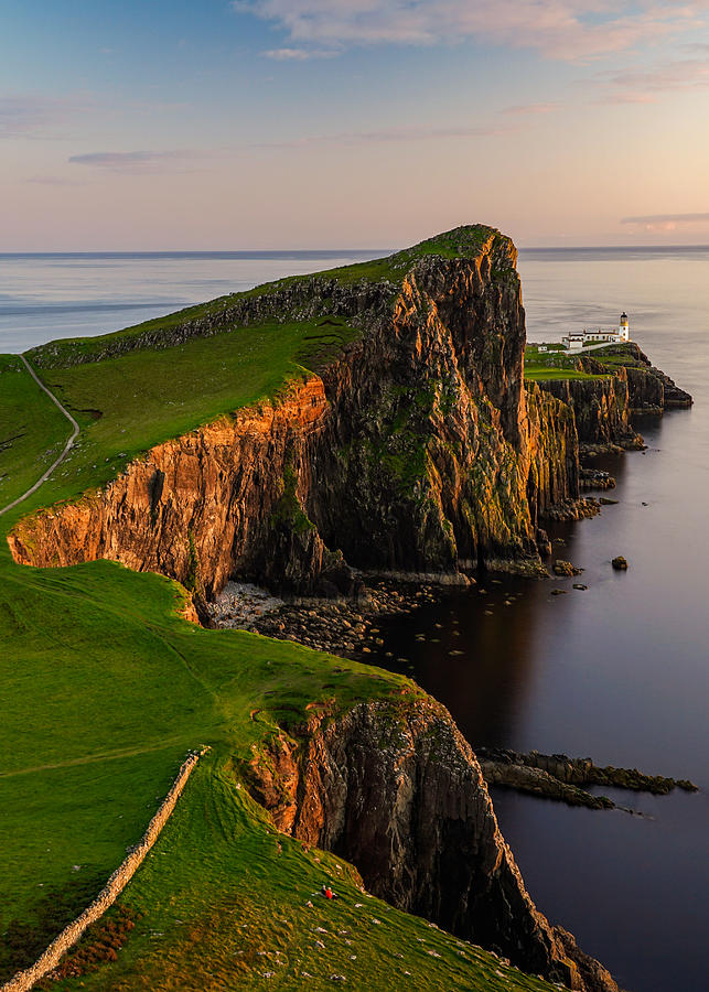 A couple enjoying their sunset at Neist Point lighthouse in Scotland. Photograph by George Afostovremea
