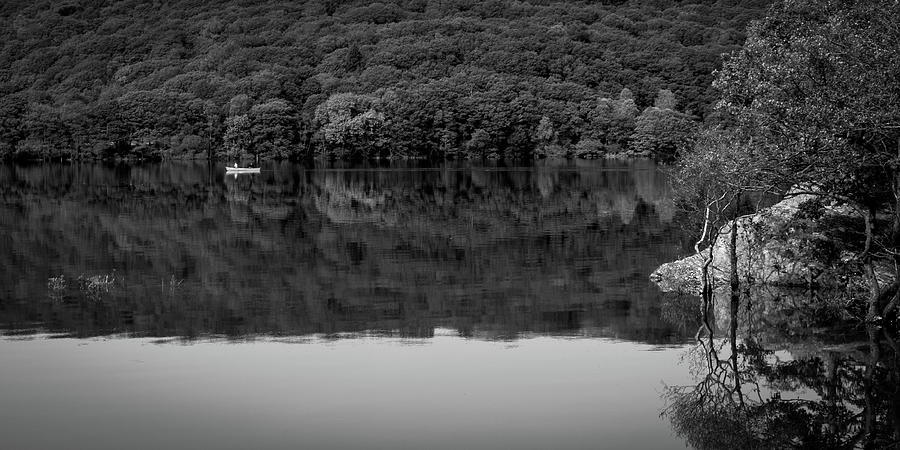 A couple pass in a canoe on Coniston Water Photograph by Seeables Visual Arts