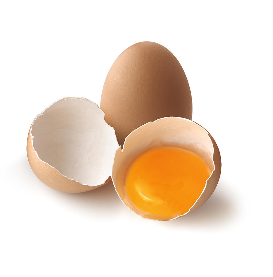 A cracked, brown egg next to a whole one Photograph by Macida