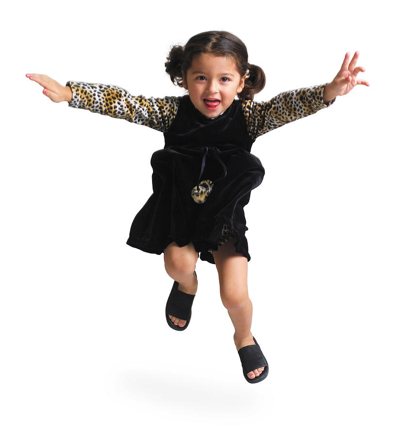 A Cute Ethnic Looking Girl In A Black Dress Jumps Up And Throws Her Arms Out Photograph by Photodisc