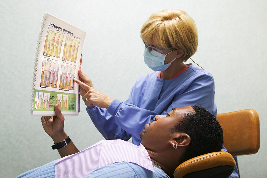 A dental hygienist shows her patient the proper way to brush teeth during a dental exam Drawing by Thinkstock