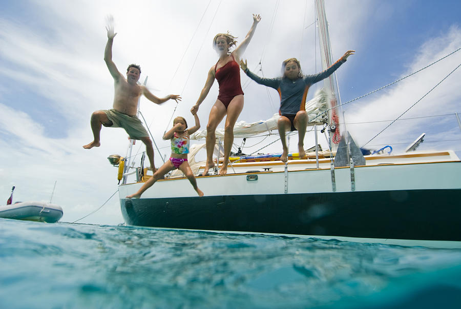 A family jumping off their boat Photograph by Jen Edney