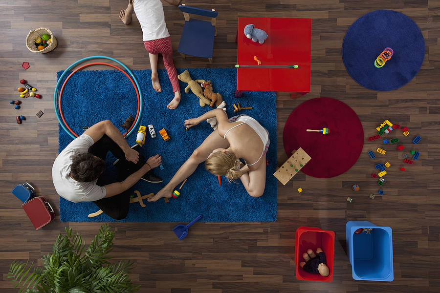 A family playing with toys in their living room, overhead view Photograph by fStop Images - Halfdark