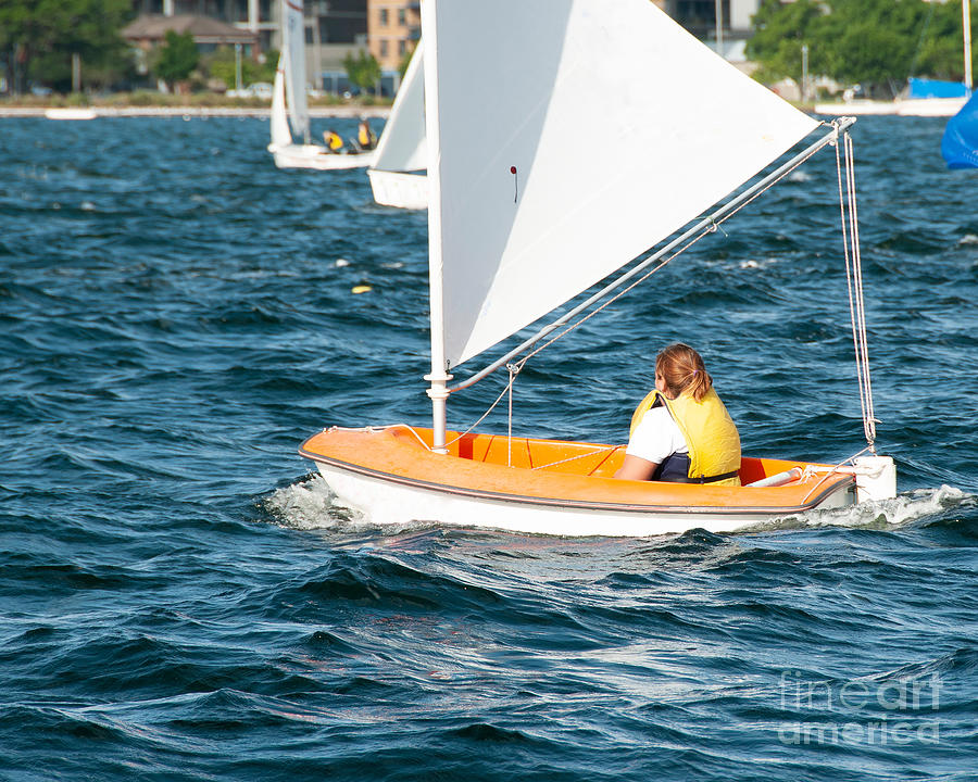 A female sailor Sailing small sailboat solo on an inland waterwa Photograph by Geoff Childs