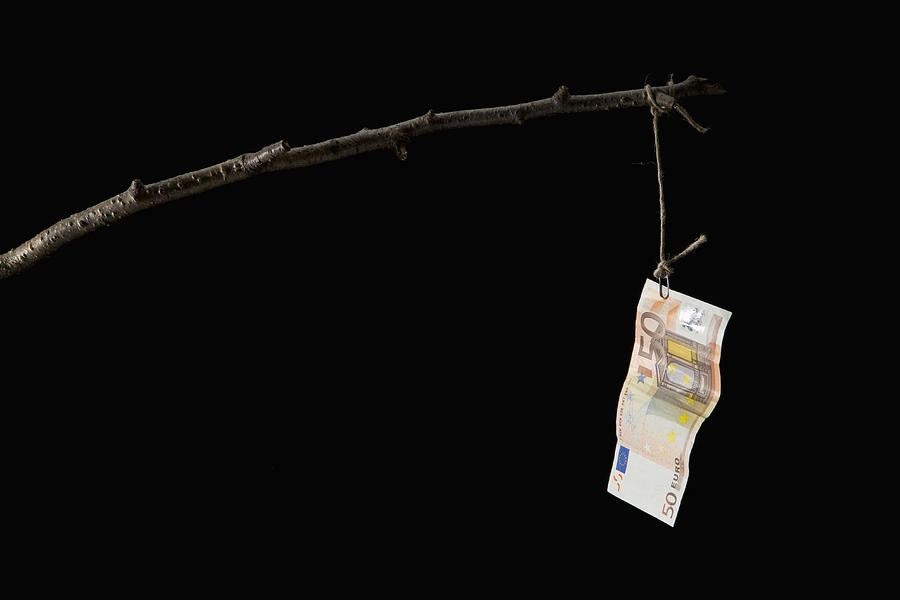 A fifty Euro banknote dangling from a crude fishing rod Photograph by Caspar Benson
