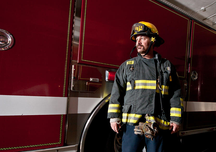 A firefighter standing in front of a fire truck Photograph by Krista Long