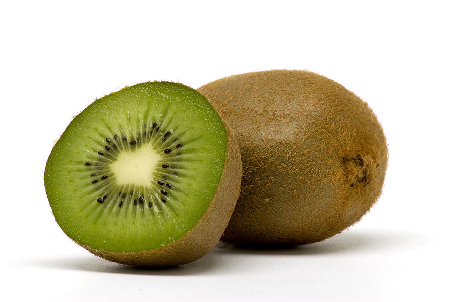 A fresh kiwi fruit cut open to reveal the green center Photograph by Magnetcreative