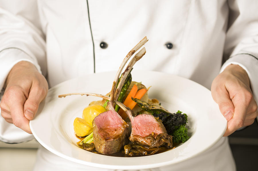 A freshly made rack of lamb being held by a chef  Photograph by stockstudioX