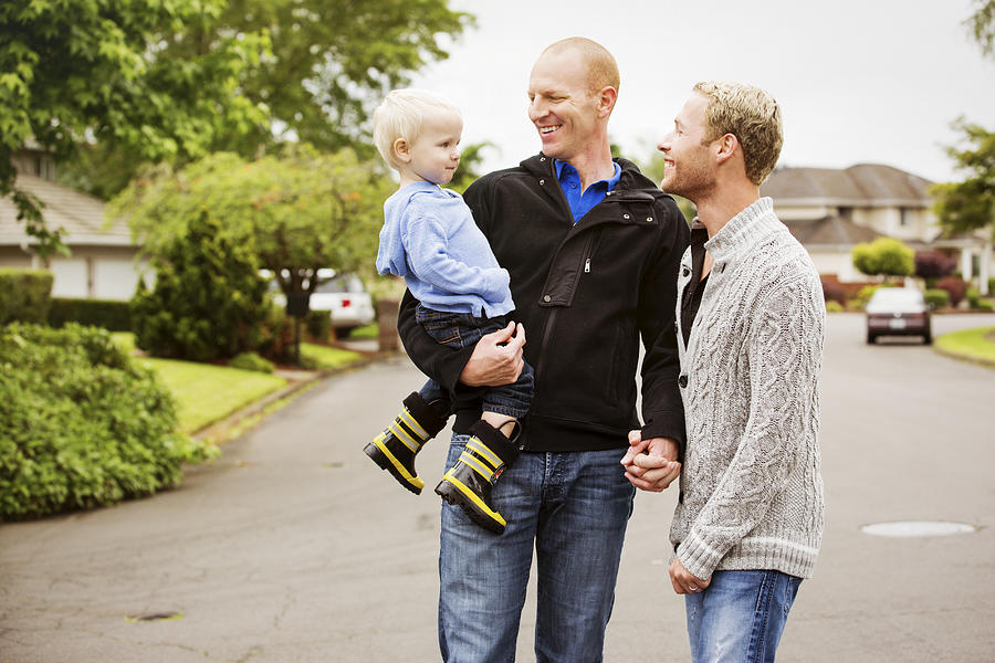 A gay couple walking with their son. Photograph by Jordan Siemens