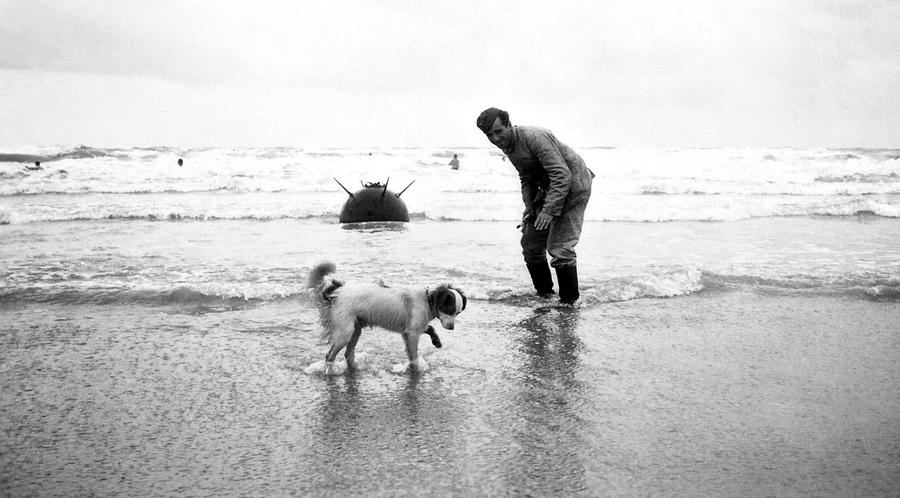 A German soldier and his dog on a beach with a Naval Mine several feet ...