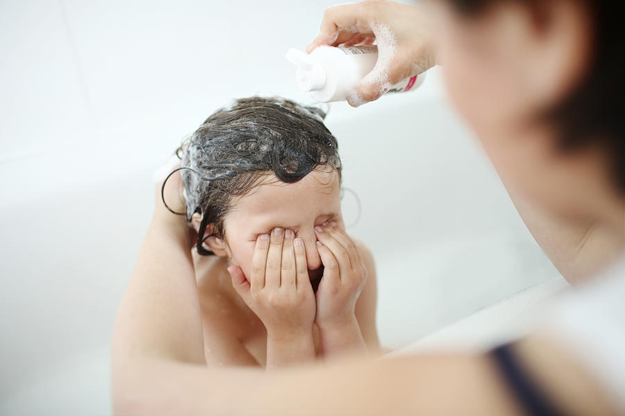 A girl having a head lice shampoo Photograph by Catherine Delahaye