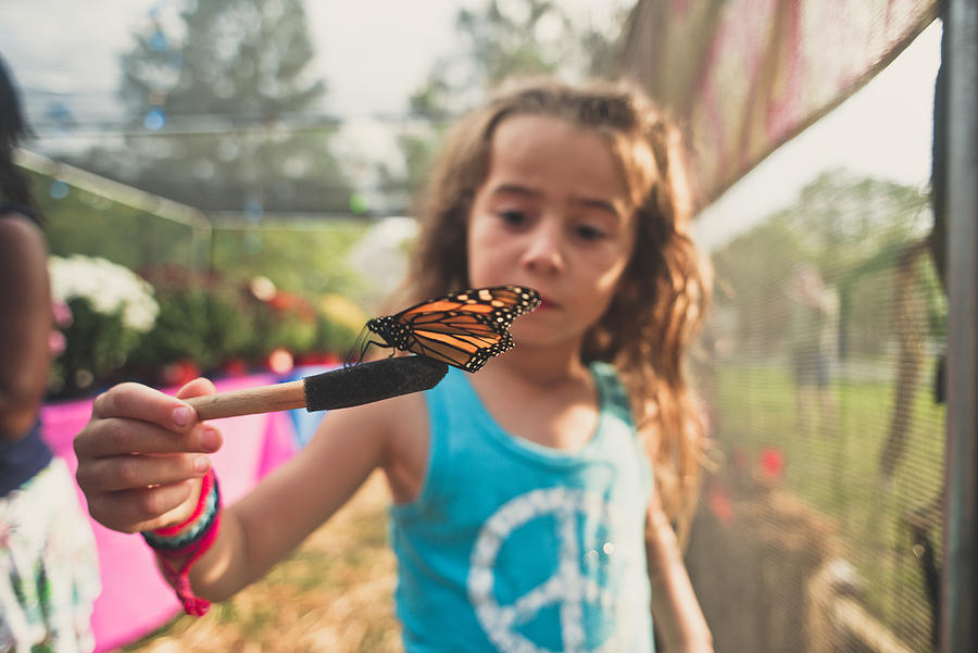 A girl holding a butterfly. Photograph by Fran Polito