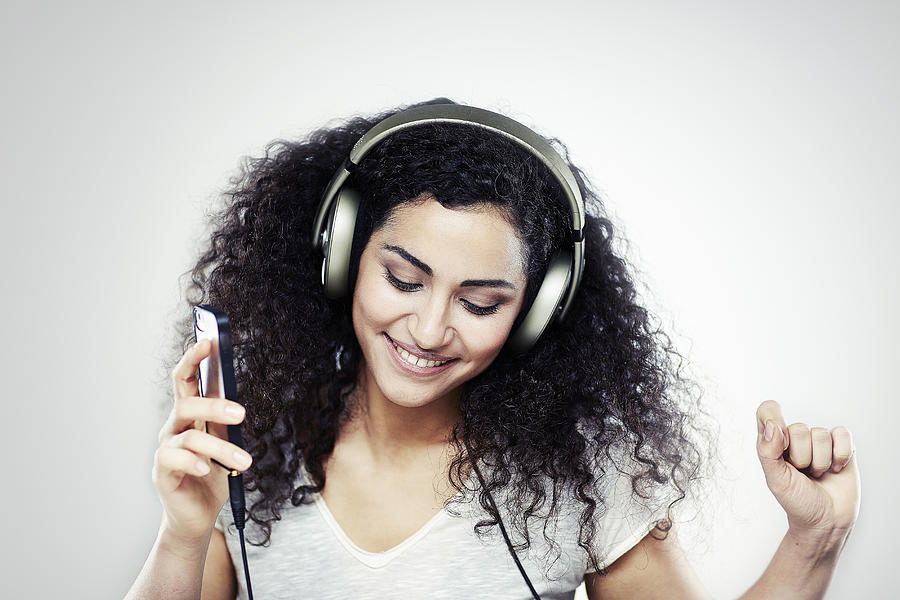 A girl listening to music with headphones on Photograph by Michael Blann