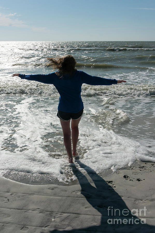 A girl wade spins along the shore at Barefoot Beach Preserve in  Photograph by William Kuta