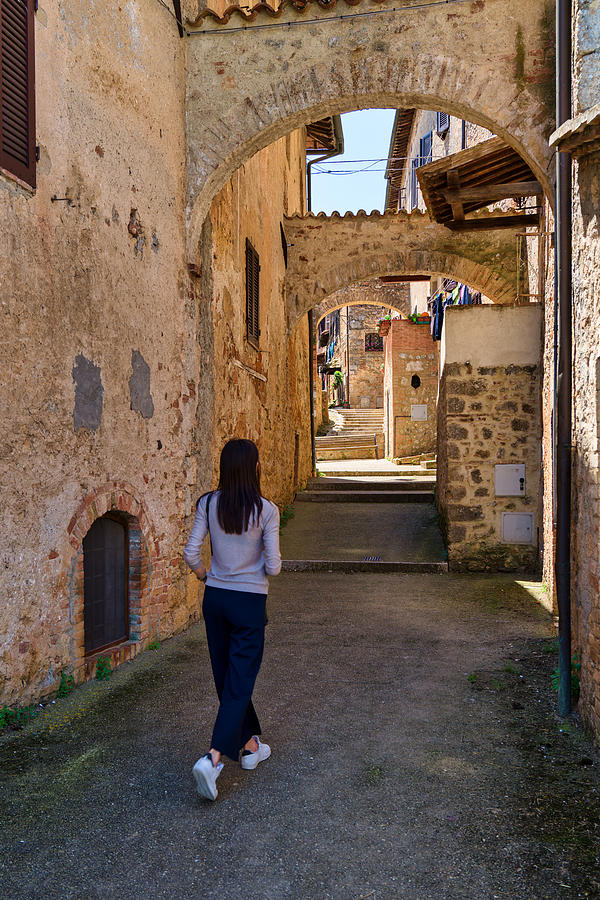 A girl walks through the streets of Abbadia Isola, Tuscany, Italy Photograph by Mauro Tandoi