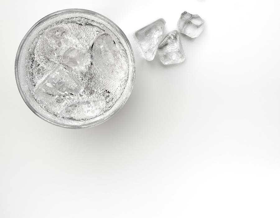 A glass of sparkling soda water with ice cubes Photograph by Anthony Bradshaw
