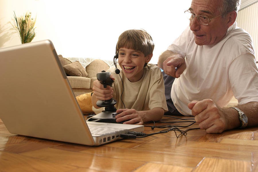 A grandfather and his grandson enjoying video games Photograph by Brasil2