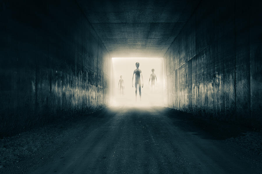 A group of aliens emerging from the light at the end of a dark sinister tunnel. With a high contrast edit. Photograph by David Wall