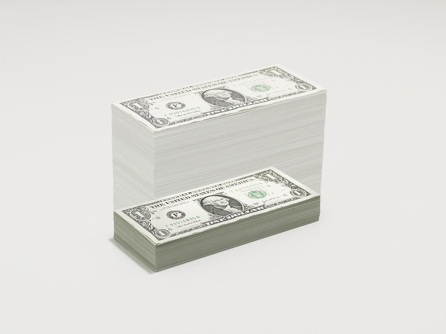 A growing pile of dollar bills Photograph by John Scott
